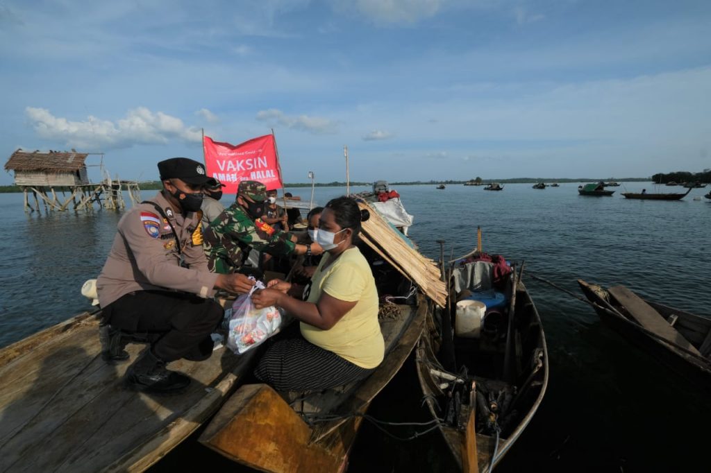 Bhabinkamtibmas Desa berakit bagikan Masker dan Sembako Pakai Perahu