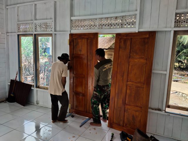 Pemasangan Pintu Musholla Noor Imam Oleh Anggota Satgas TMMD Bersama Warga